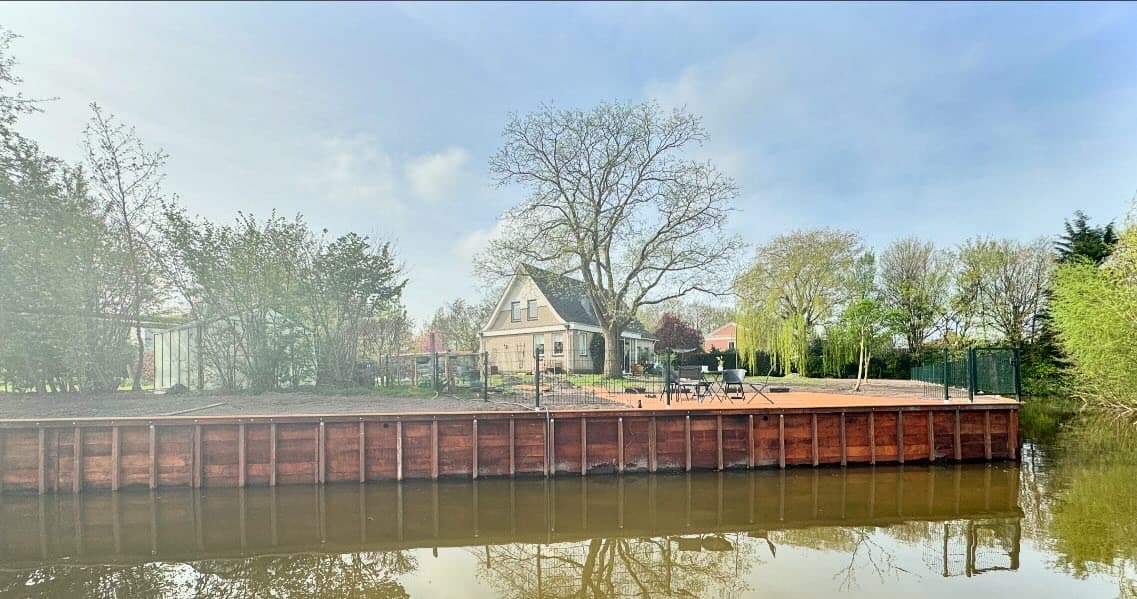 Nieuwe houten beschoeiing langs het water