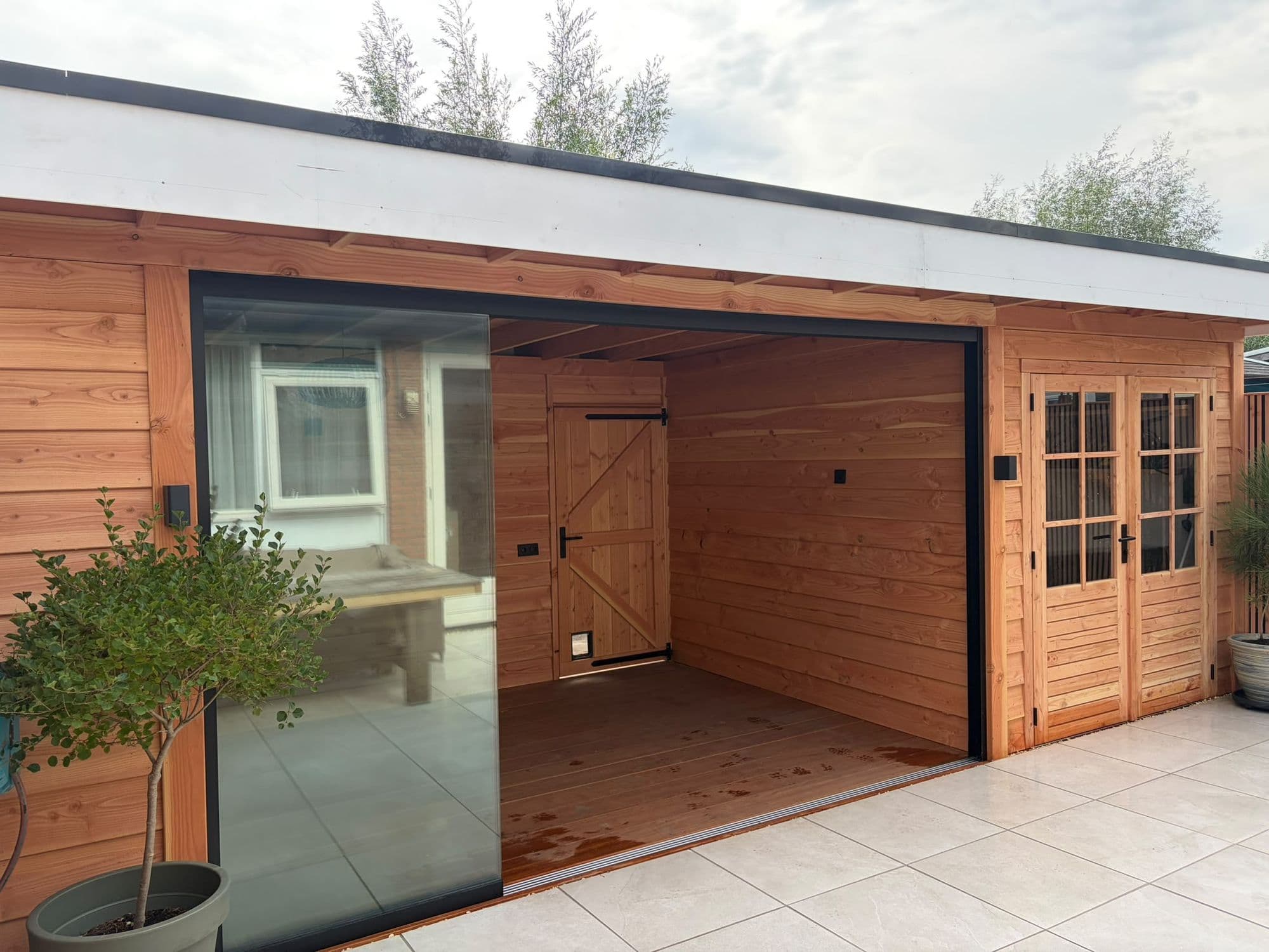 Tuinkamer van Douglashout met glazen schuifwand en berging