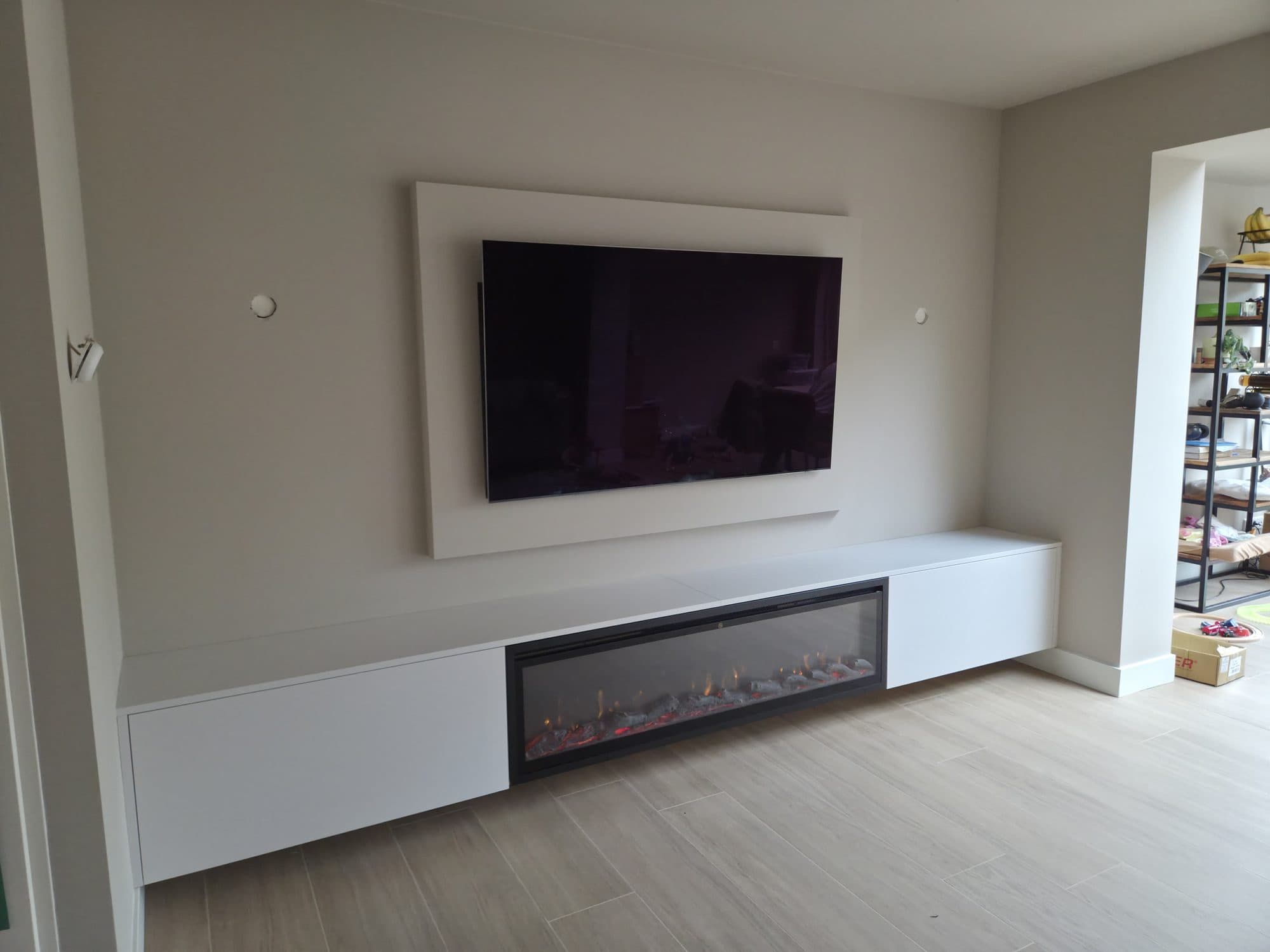 Tv-wand met zwevend tv-meubel en ingebouwde sfeerhaard