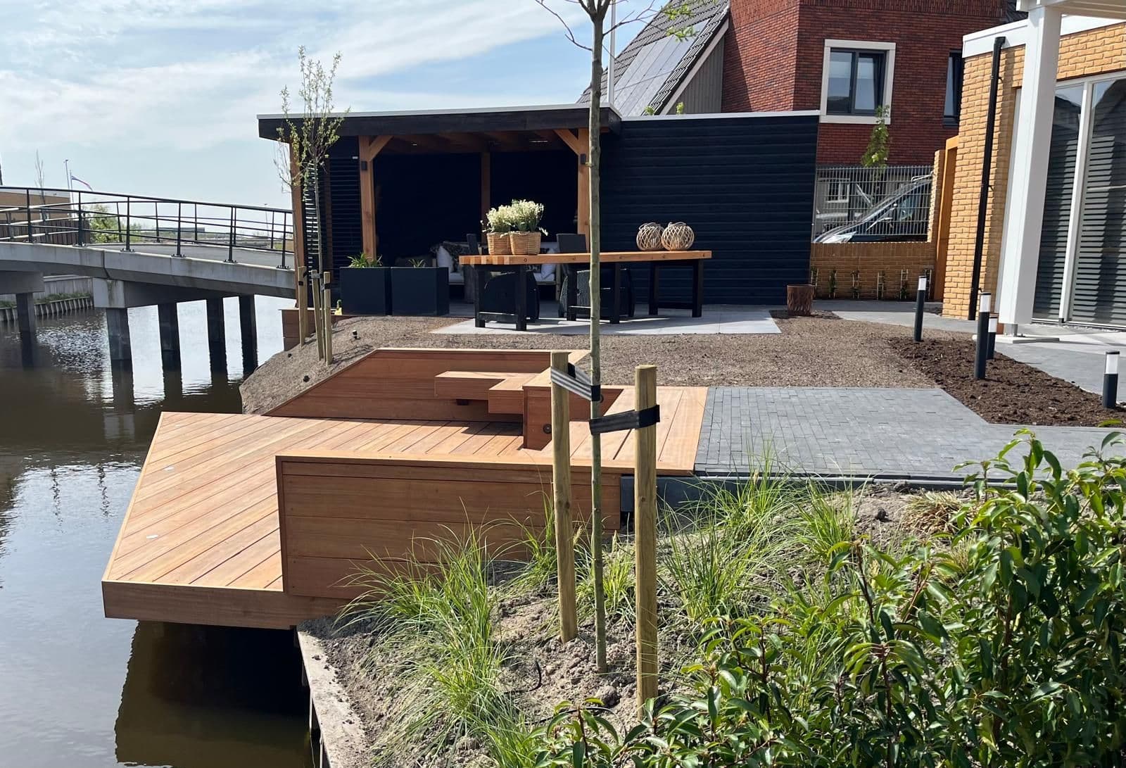Nieuw aangelegde tuin aan het water met vlonder en terras