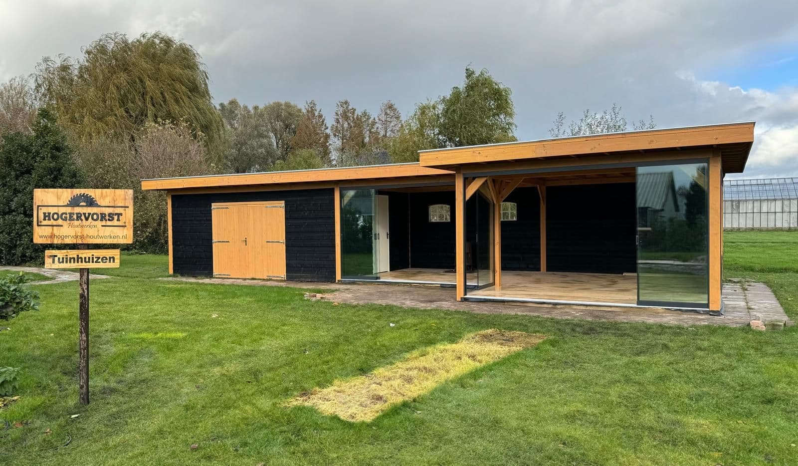 Tuinkamer met zwarte gevel en Douglashout, met glazen schuifwanden